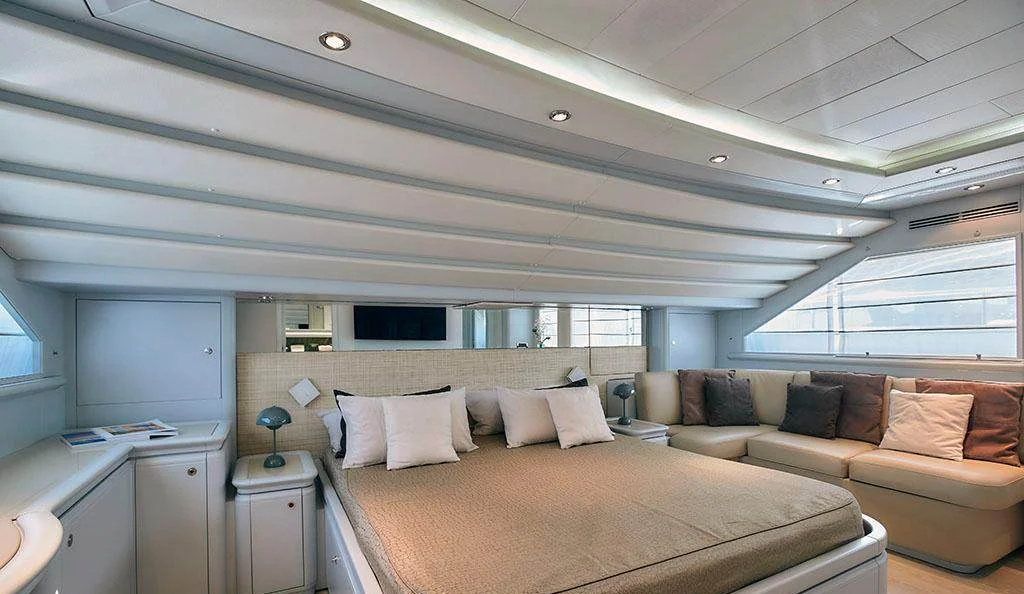 Master cabin aboard Camarik showing bed and lounge seating