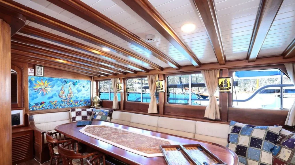 Aegean Clipper wood-panelled interior saloon with dining table and backgammon board