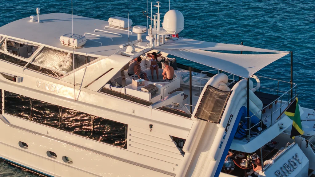 Sun deck lounge area aboard motor yacht Birdy with BIRDY lettering visible on the superstructure