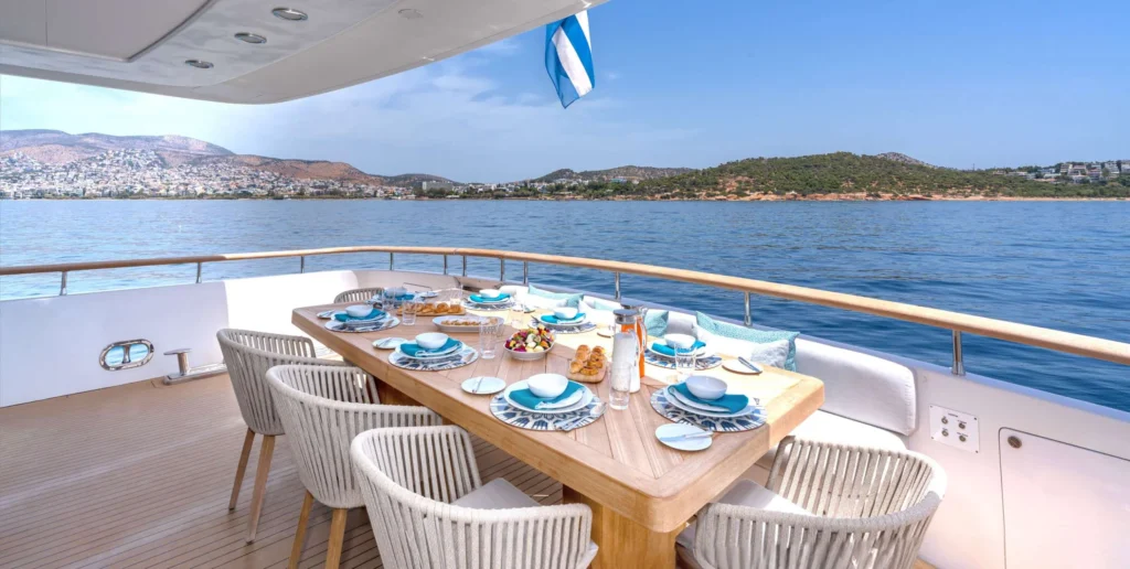 Aft deck alfresco dining setup aboard Gladius motor yacht with Greek coastal views