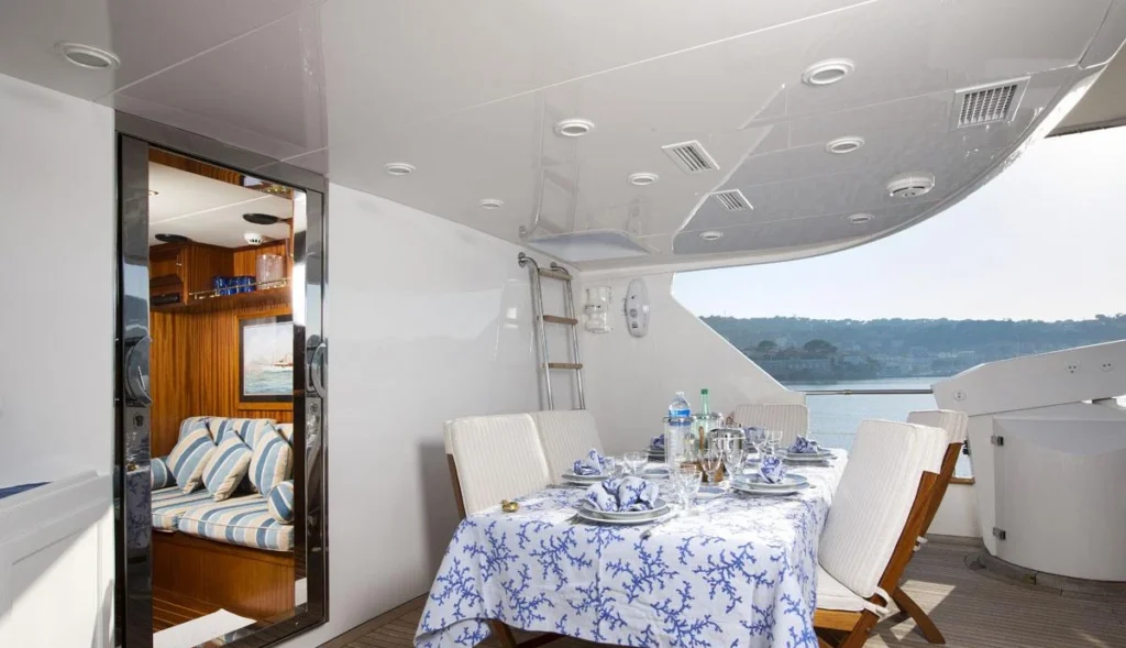 Al fresco dining table set on the aft deck of charter yacht Mizar