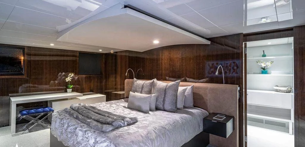 Master suite aboard Oculus with king bed and dark wood paneling