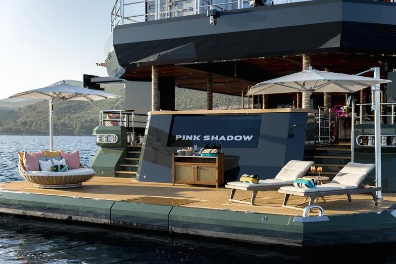 Aft swim platform and lounge deck aboard Pink Shadow with the yacht name visible on the hull