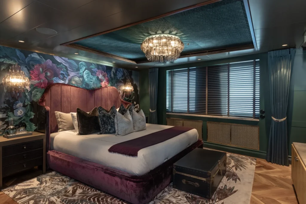 Guest cabin aboard Pink Shadow with floral wallpaper and velvet bed